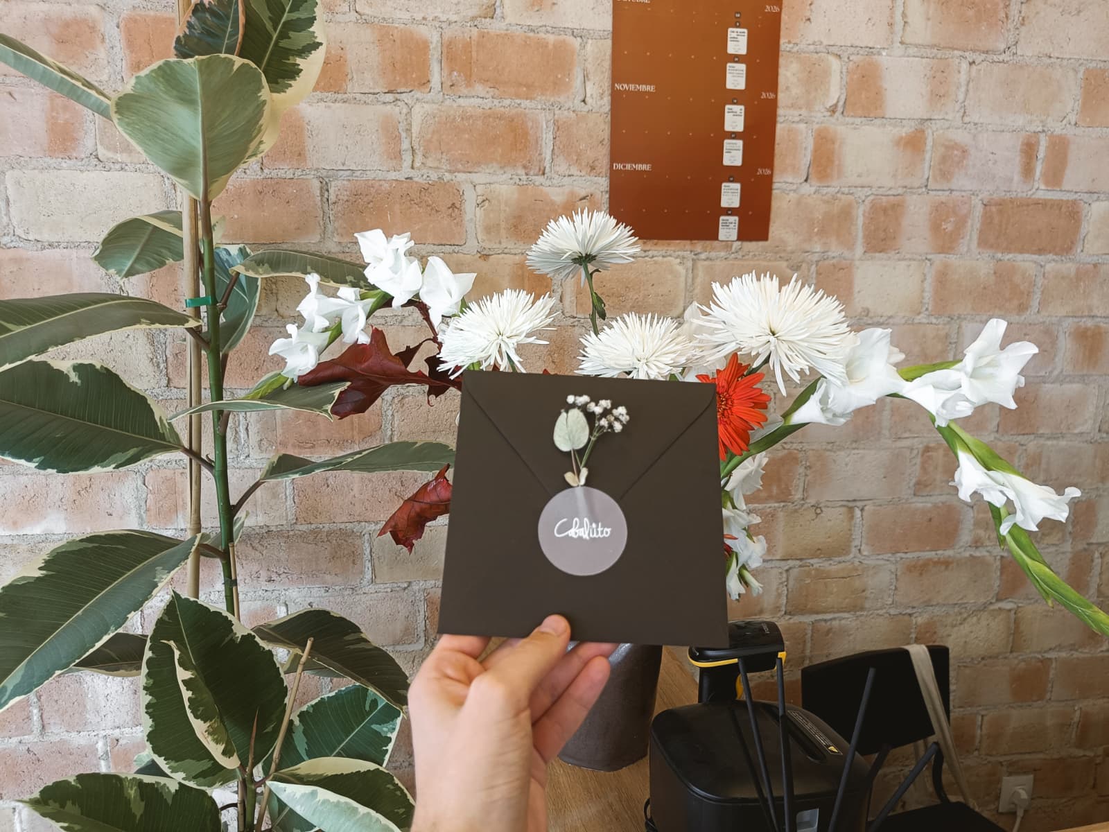 Sobre verde oliva de la tarjeta regalo, adornado con flores y sello Cabaliito